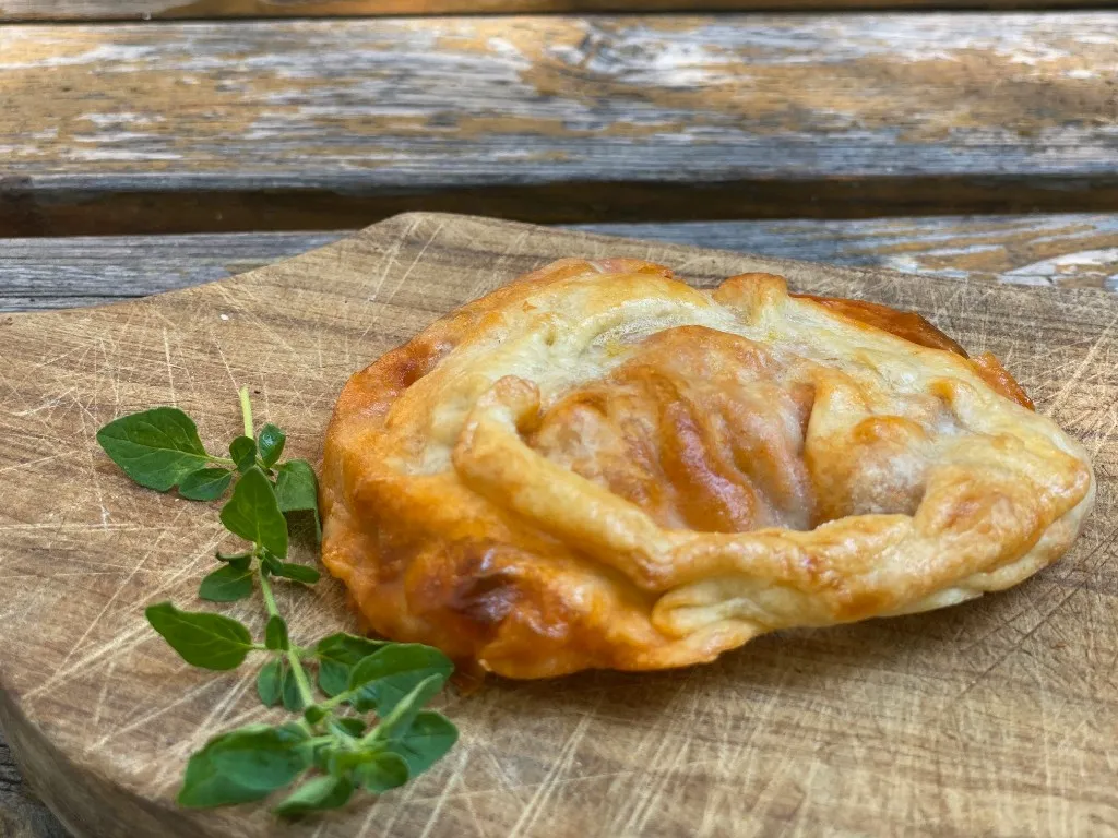 Gemüse-Empanada im Schnitt, mit Paprika, Zwiebeln und Kräutern